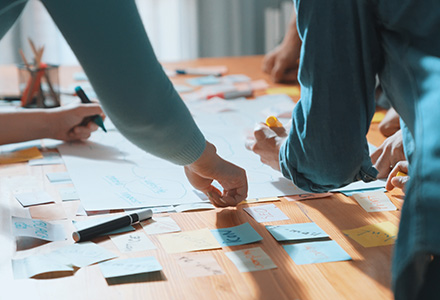 Close-up of team brainstorming ideas on a table with Post-its and markers